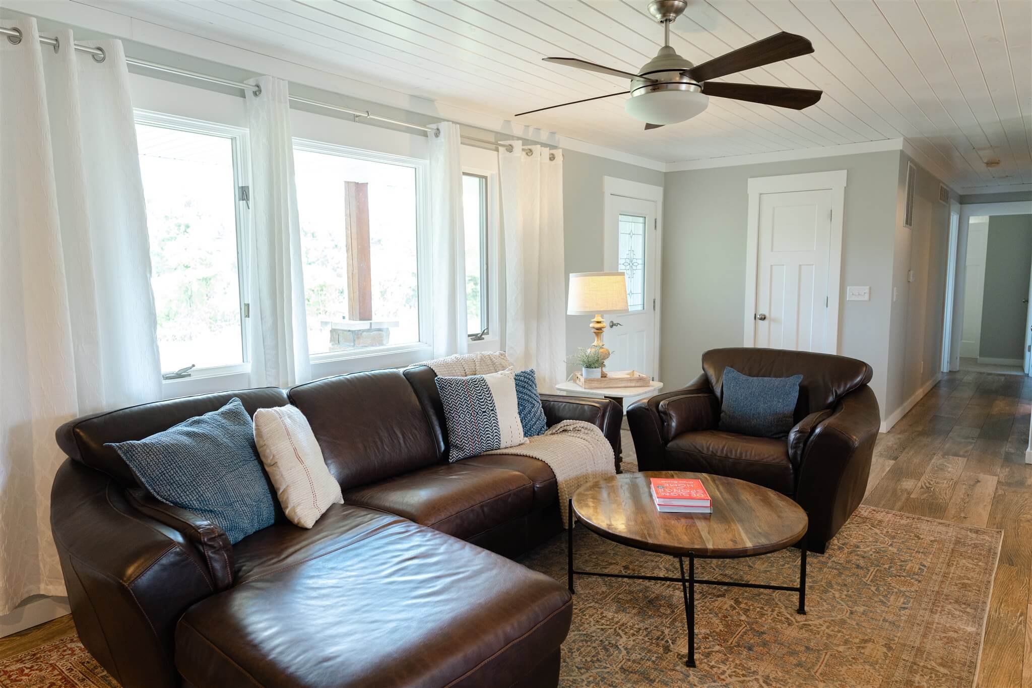 Living room with leather sectional and big windows