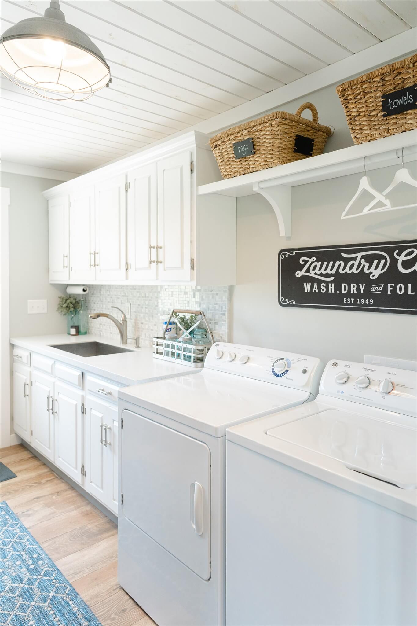 Bright laundry room with washer, dryer, and storage